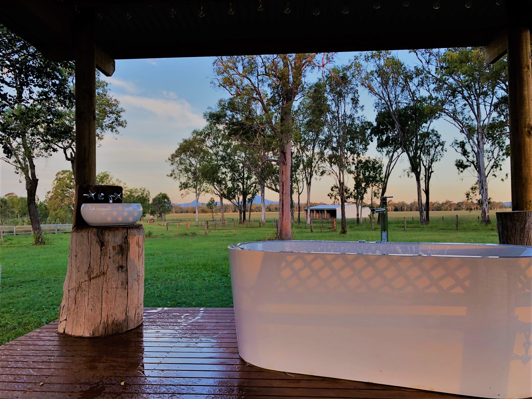 a bath on a verandah overlooking farmland