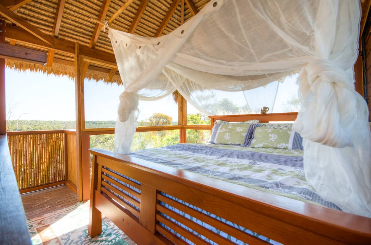 a bed with a net on it in what looks like a treehouse