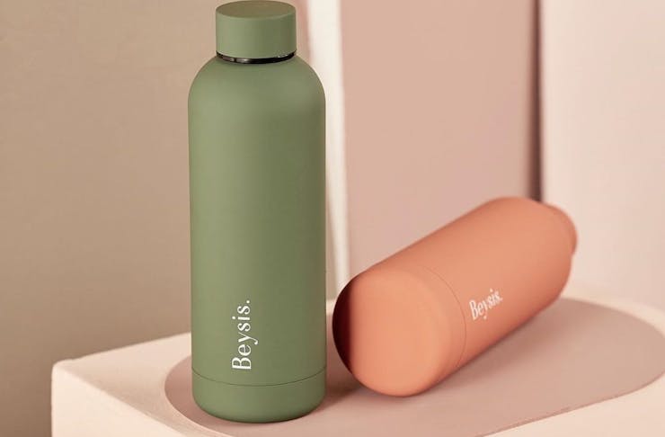 A sleek green and peach water bottle lie side by side.
