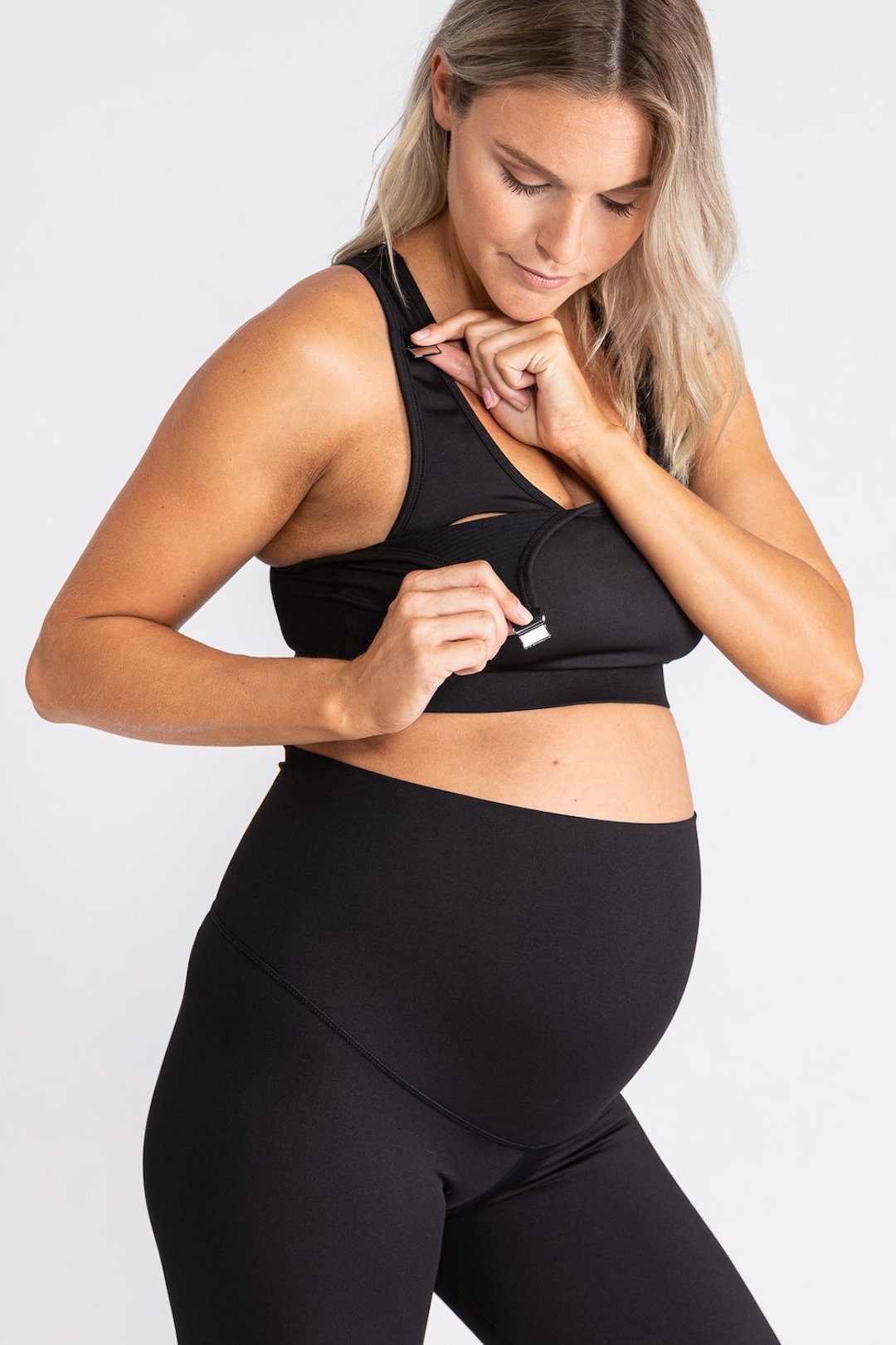 A pregnant woman wears a chic maternity breastfeeding crop top.