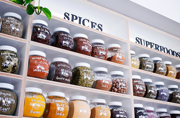 A wall of jars filled with spices and dried herbs and one of Perth's bulk food stores.