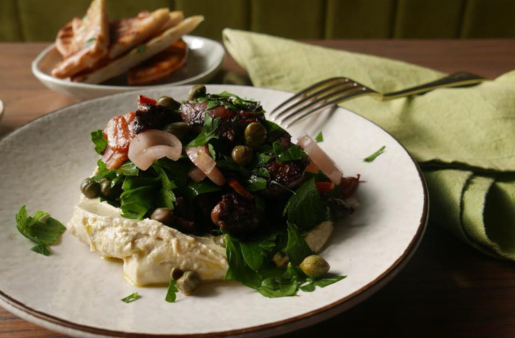 Chicken hearts are delicately positioned on a plate with a variety of garnishes