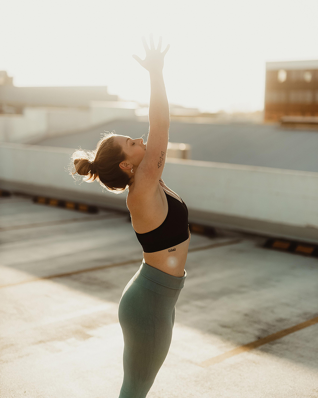 A person performs a sun salutation on a rooftop at Every Day You, one of the best online fitness programmes.