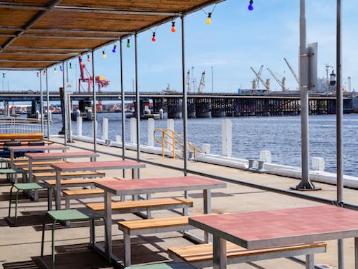 A series of outdoor tables by the water.