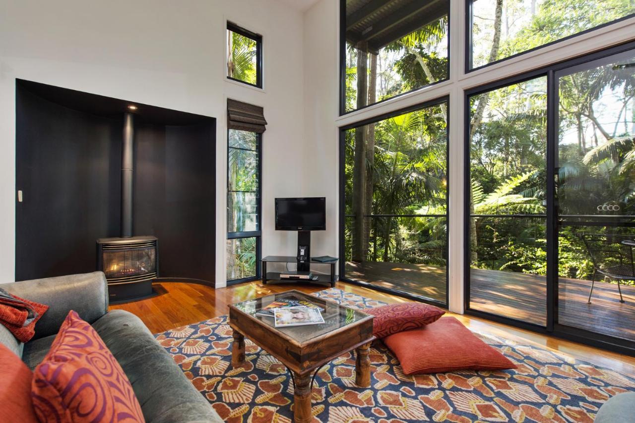 Living room area with large windows overlooking the rainforest.