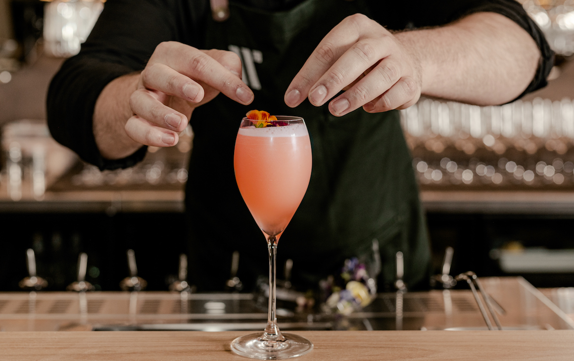 a bartending serving a cocktail