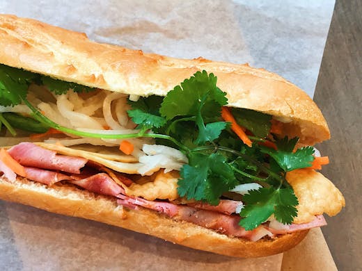 A banh mi roll on white paper