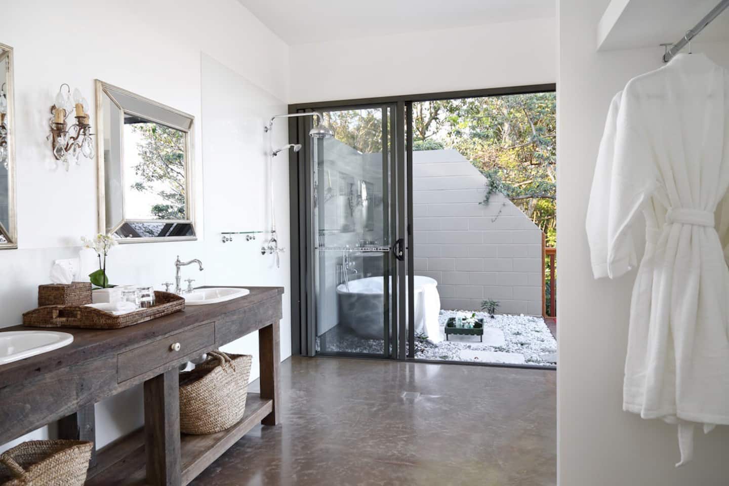a bath in a courtyard visible through a bathroom door