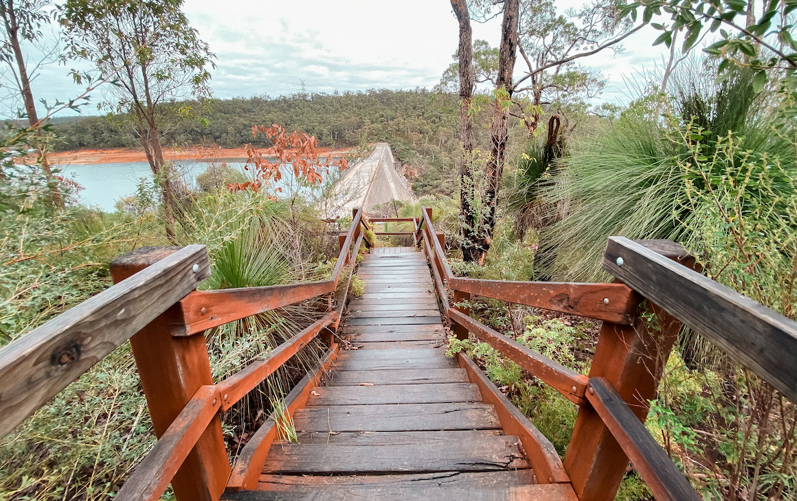 a timber walkway leading down to a dam