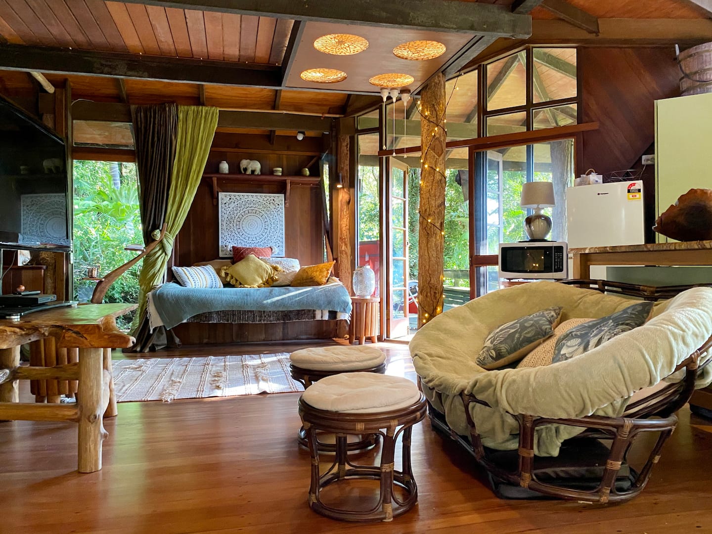 a lounge room in a large treehouse-like cabin