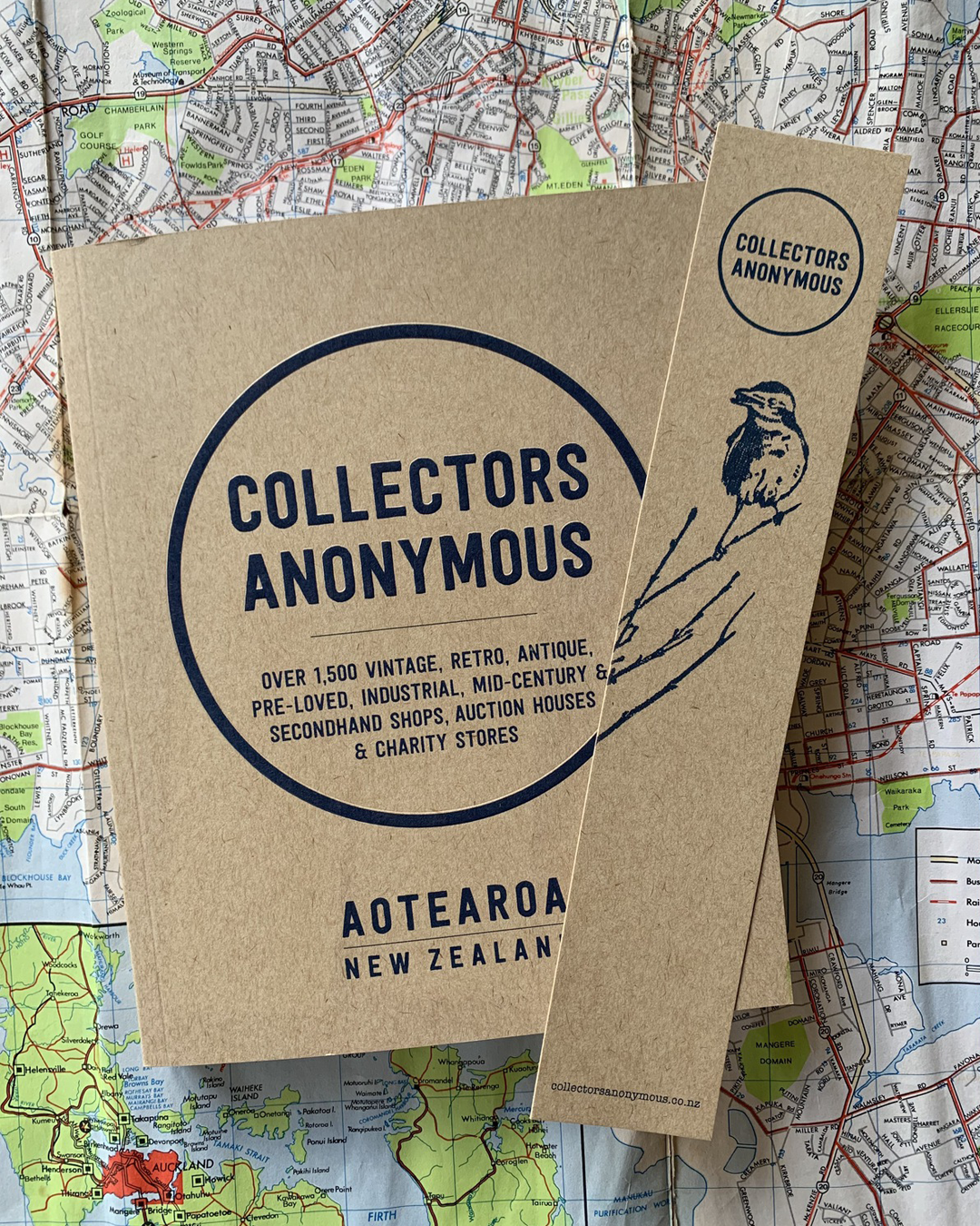 A recycled paper book titled 'Collectors Anonymous' sitting on top of a map.