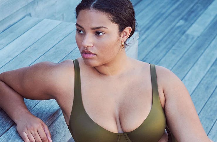 A woman in an olive-coloured bra from the brand CUUP.  