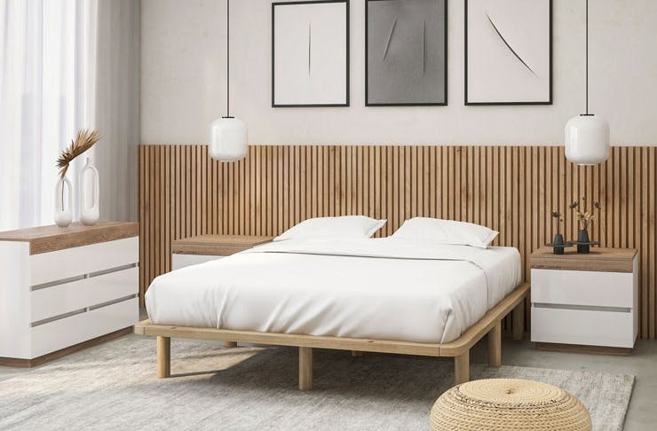 A Scandi-style bedroom, complete with a plush white bed and wooden bed base. 