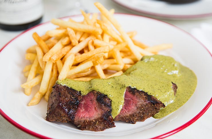 A steak from Entrecôte covered in their herb and butter sauce.