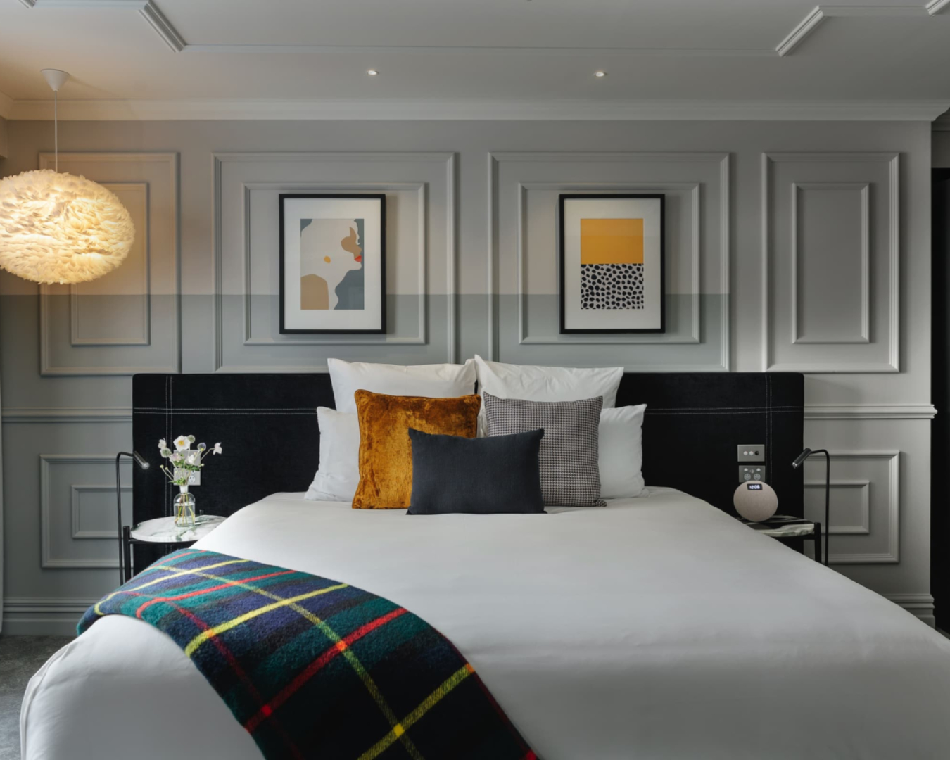 An elegant guest suite at the Fable Hotel in Dunedin, featuring a plush bed with tartan plaid