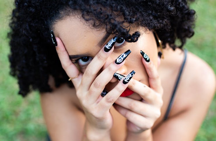Woman covering her face with her hands, Best Places To Get Your Nails Done in Auckland