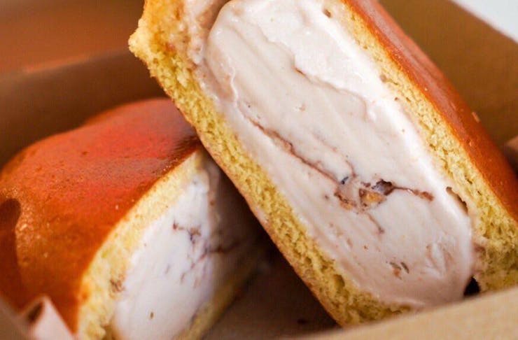 A close-up shot of two pieces of gelato wrapped in a golden layer of brioche.