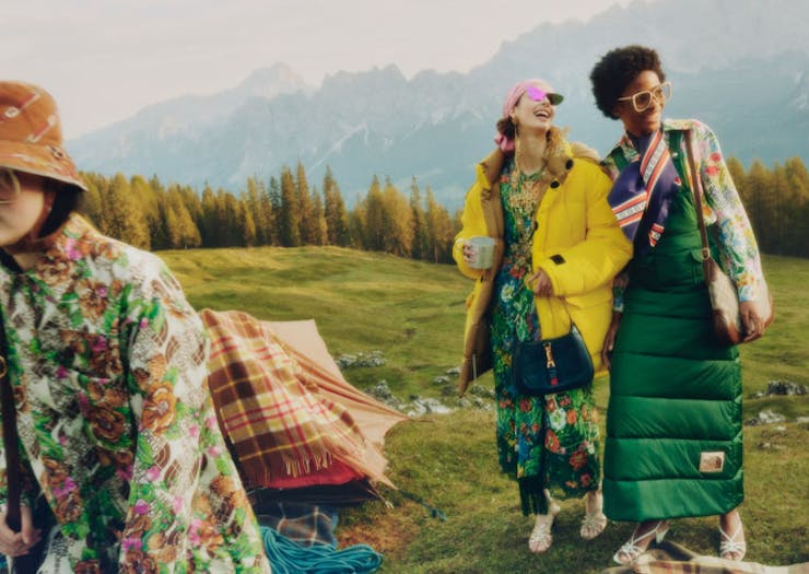 Three people dressed in The North Face x Gucci on a grassy hill. 