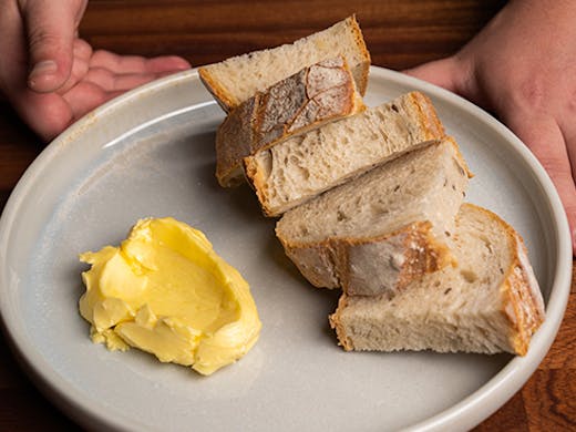 Four slices of sourdough on a plate with butter
