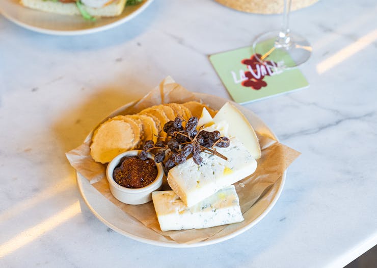 a cheese board with a glass of wine