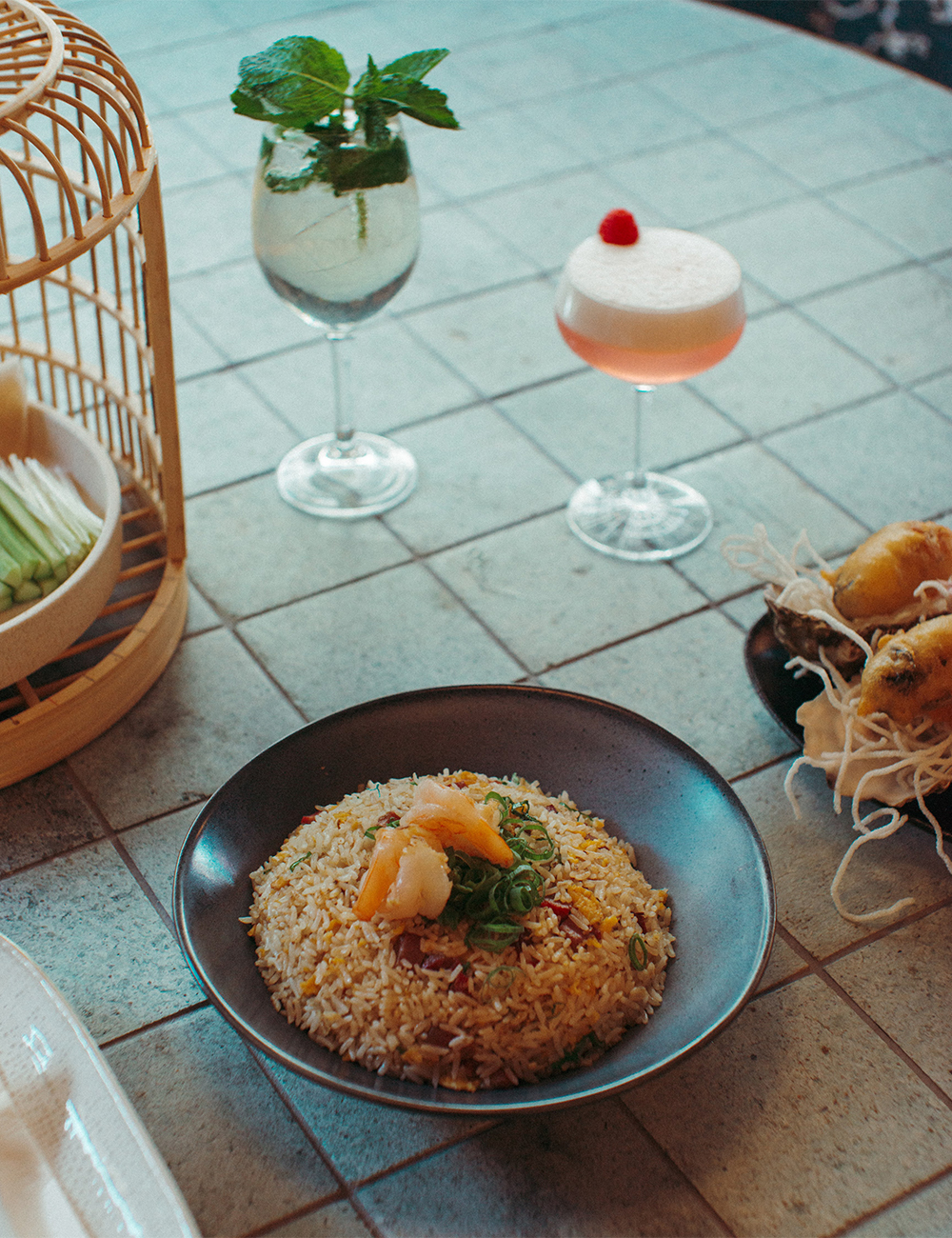 a dish of fried rice on a table with cocktails