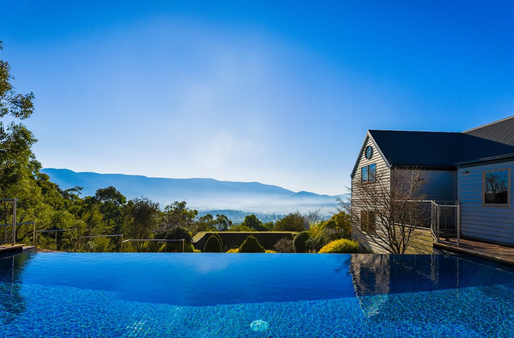A pool overlooking mountains on a misty morning.