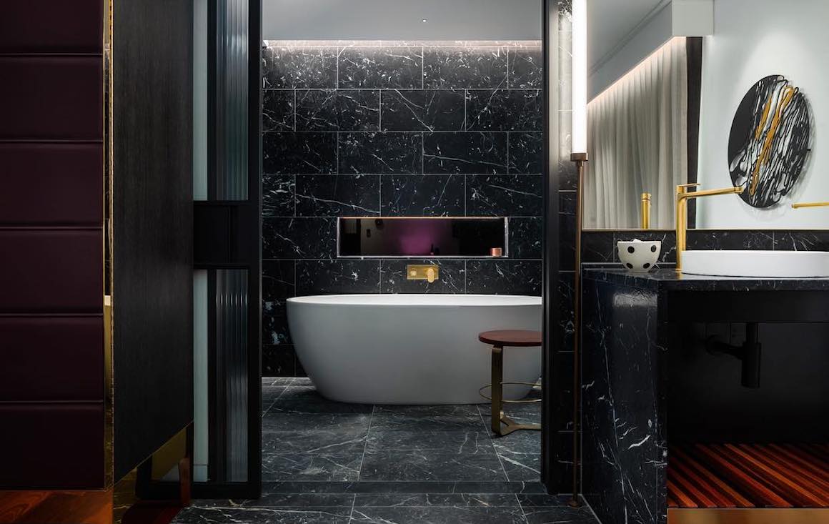 a black marble bathroom with big tub