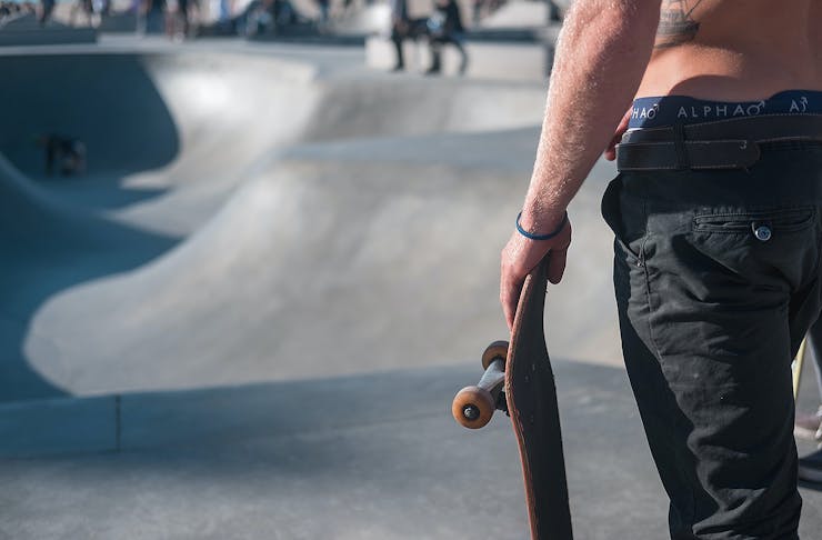 A man waits to drop in at a skate park.