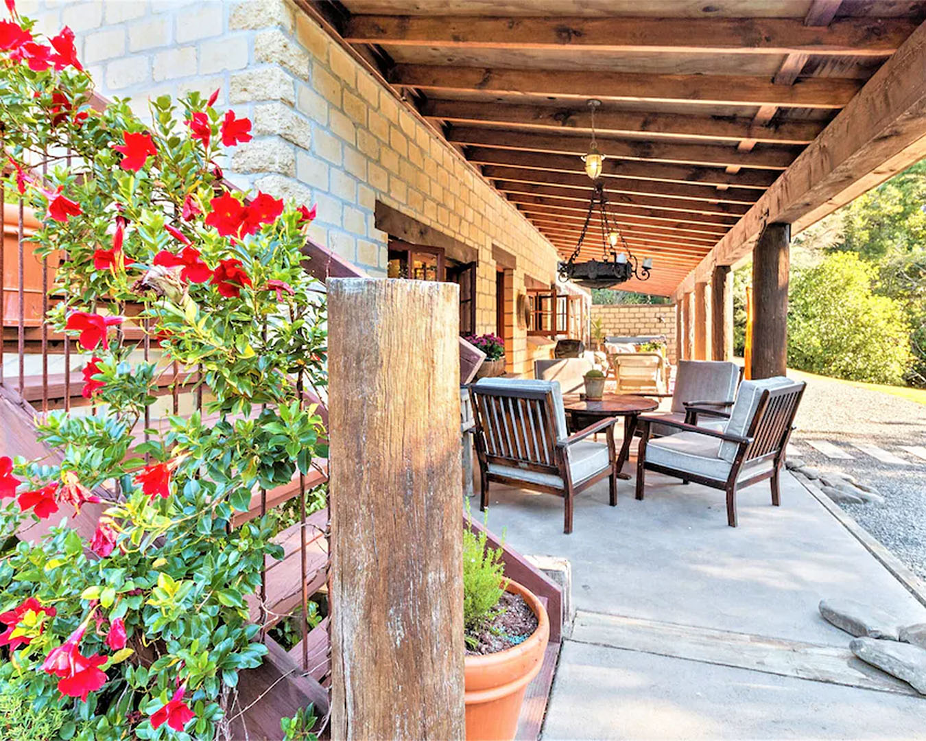 Villa Casa Maria showing an outdoor Tuscan vibe with wooden beams, chairs and an abundance of flowers.