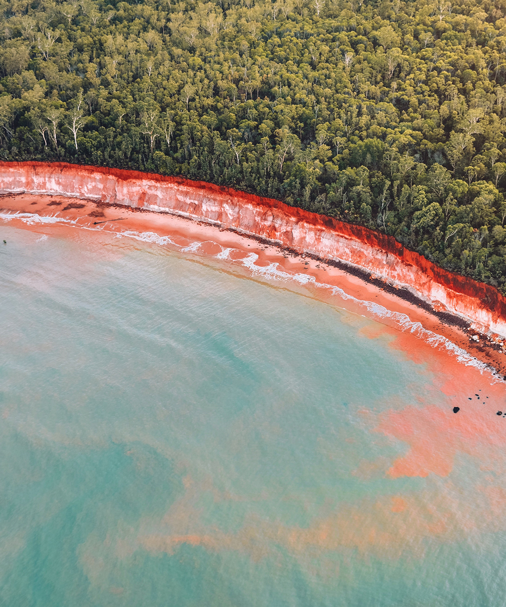 sparkling blue water meets red sand and lush mangroves on the Tiwi Islands