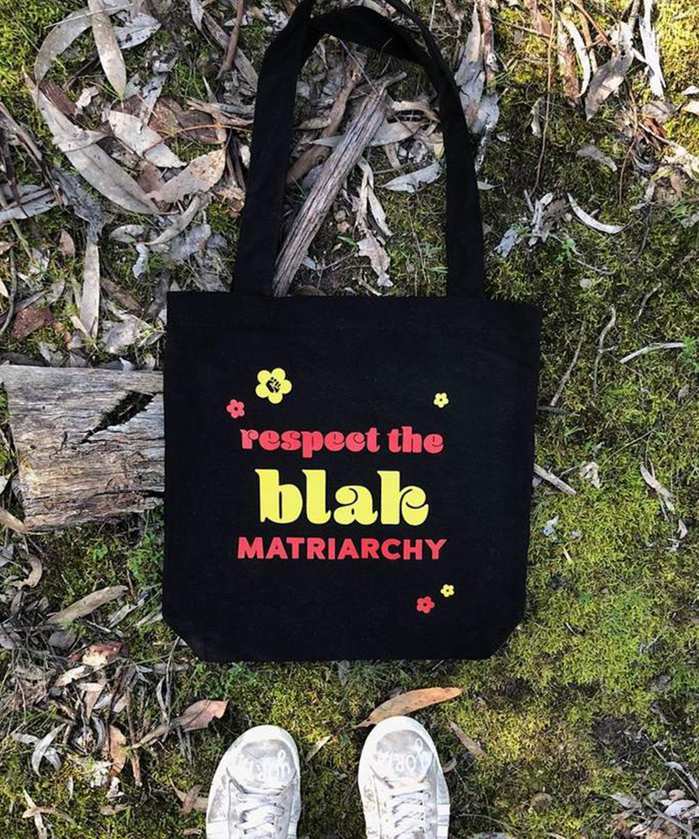 a black tote with the text 'respect the blak matriarchy' on it.