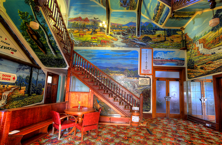 inside of palace hotel — foyer is painted completely in bright murals of australian outback