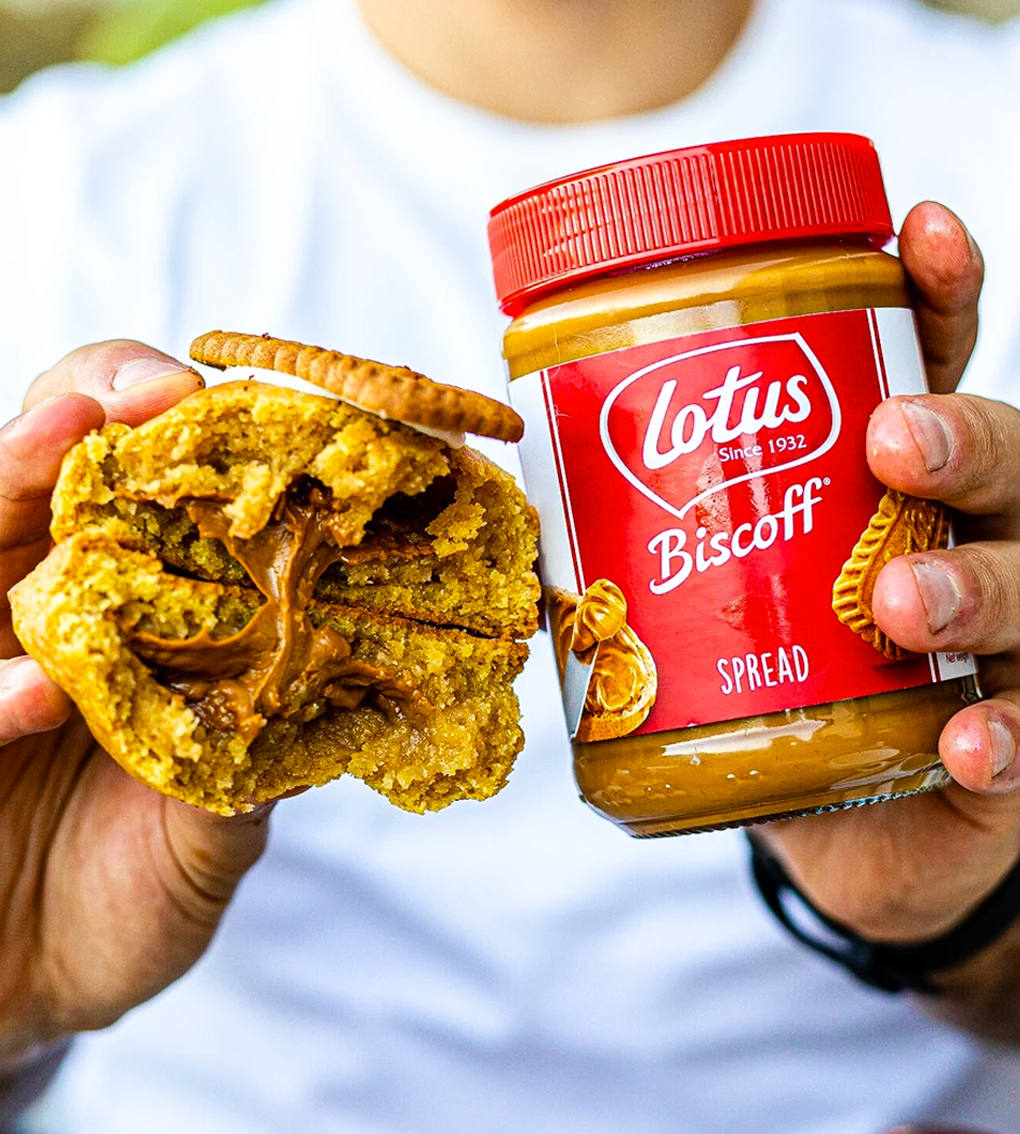 hands hold ing chunky cookie and lotus biscoff spread jar