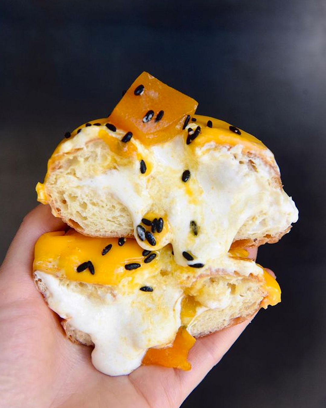 hand holding passionfruit curd  doughnut